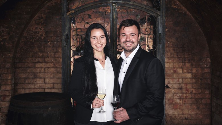 Weingut Döllinger, © Markus Lang-Bichl Ein Mann und eine Frau in eleganter Kleidung stehen in einem Weinkeller mit Weingläsern in der Hand.