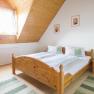 Doppelzimmer, © Winzerhof Semmler Gemütliches Schlafzimmer mit Holzmöbeln und Dachschräge.