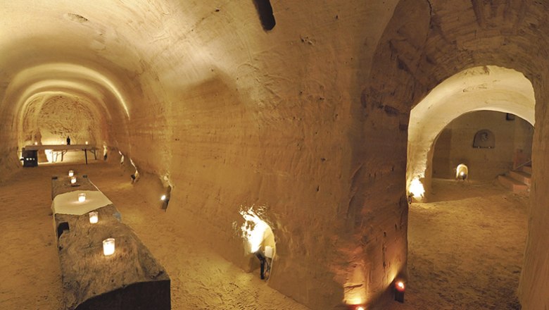 Himmelkeller, © Himmelkeller Unterirdischer Sandsteinkeller mit Kerzenlicht und rustikalen Tischen.