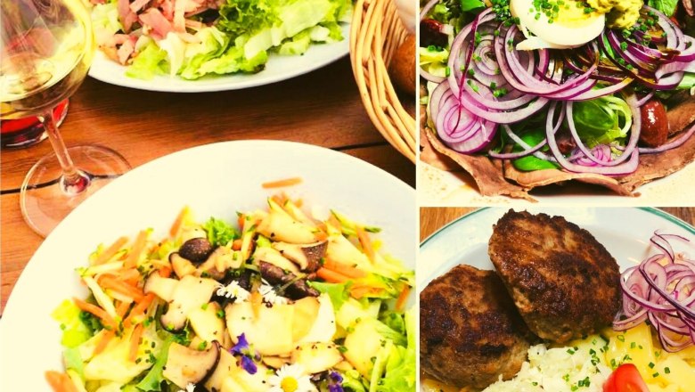 Speisen, © Weingut Hess Verschiedene Teller mit Salaten, Fleisch und einem Glas Weißwein.