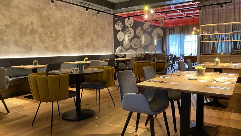 Modernes Restaurant mit stilvoller Einrichtung, Holztischen und gem&uuml;tlichen St&uuml;hlen.