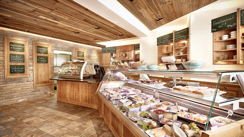 Innenansicht eines Heurigenlokals mit Theke und Speisen.