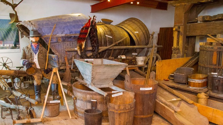 Ausstellung mit alten landwirtschaftlichen Ger&auml;ten und Holzf&auml;ssern.
