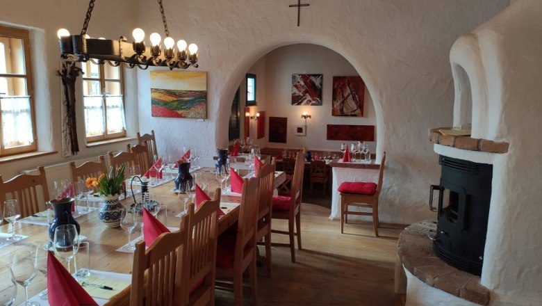 Gemütlicher Raum mit gedecktem Tisch, Weingläsern und Kamin.