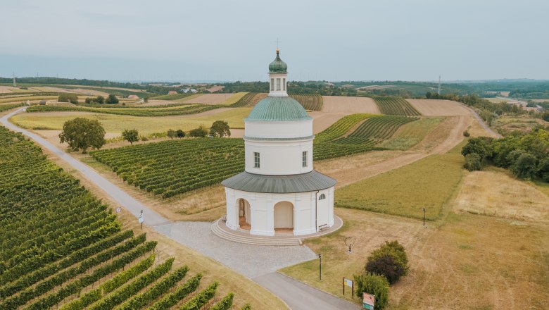 Luftaufnahme der Rochuskapelle am Rochusberg in Mannersdorf, umgeben von Weinbergen und Feldern.