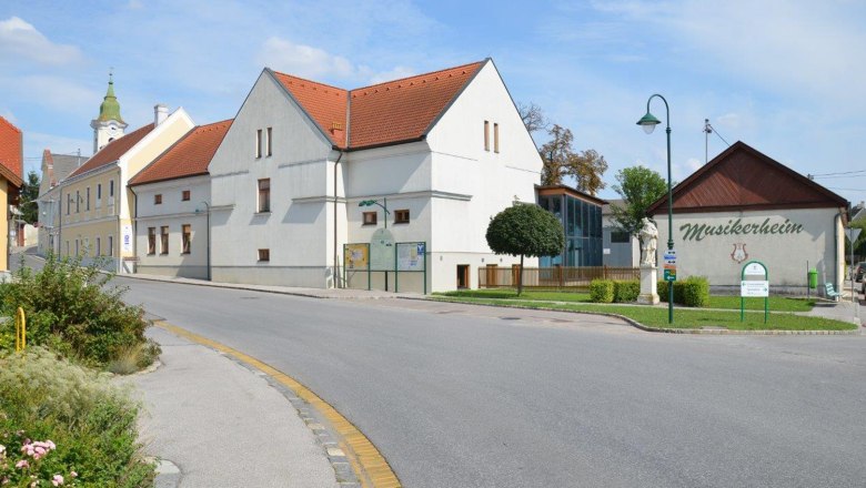 Stra&szlig;enszene in Hohenruppersdorf mit Musikerheim und Kirche im Hintergrund.
