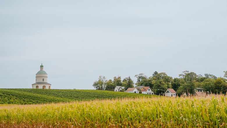 Rochuskapelle auf einem Hügel mit umliegenden Feldern und Häusern.